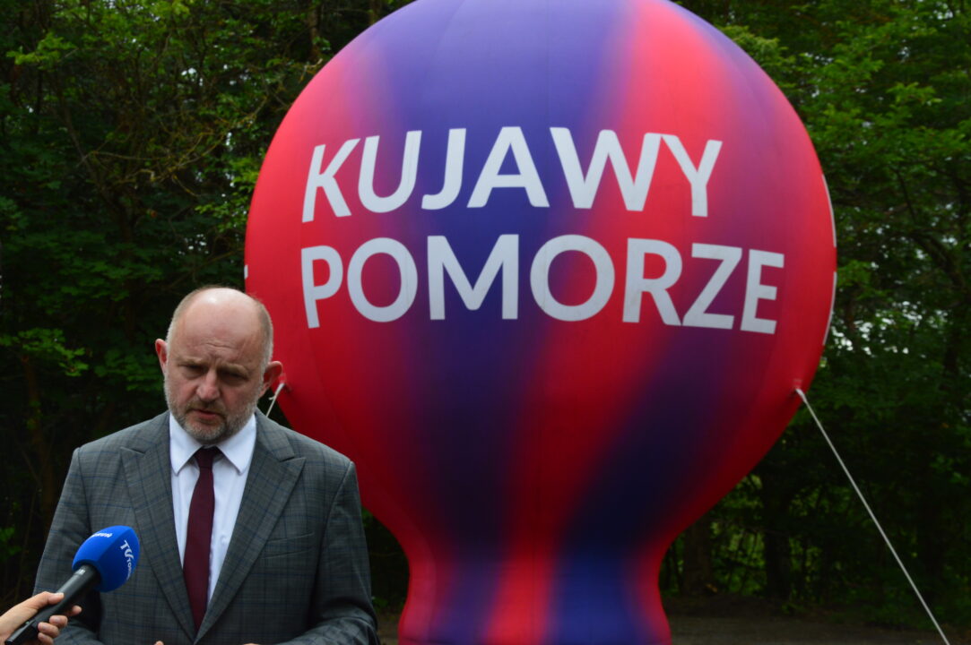 Dzień otwarty w KPFP - Marszałek Piotr Całbecki na tle balona z napisem Kujawy Pomorze